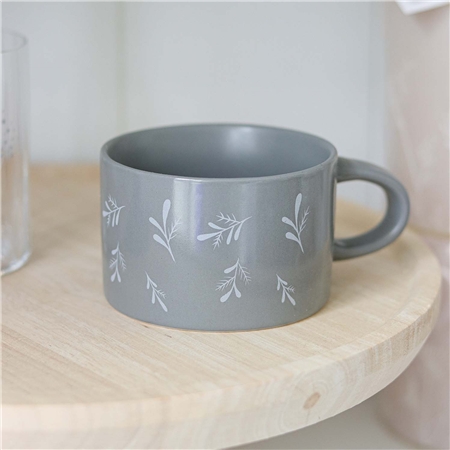 Sivý hrnček s padajúcimi vetvičkami